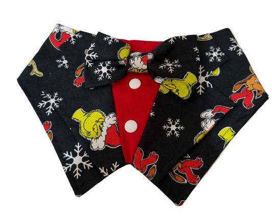 A novelty pet collar shaped like a bow tie, featuring a black background with a Grinch-themed holiday print of white snowflakes, red Santa accents, and yellow Grinch figures, with a red center panel and white buttons.
